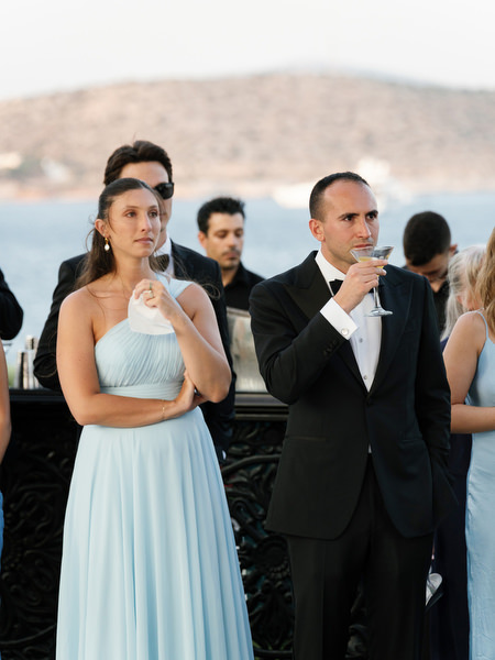 Wedding guests reacting emotionally during outdoor dinner at The Residence Island Resort Athens Riviera.