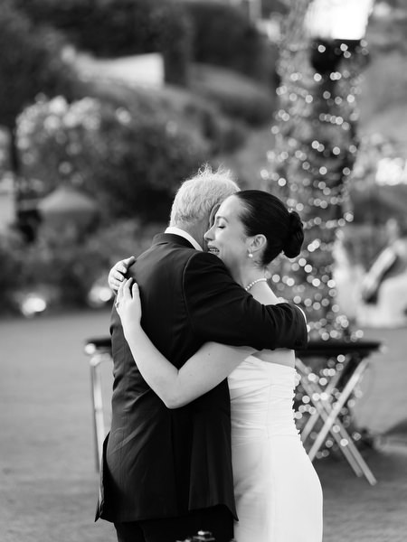 Bride hugging her father during emotional speech at Athens Riviera wedding reception.