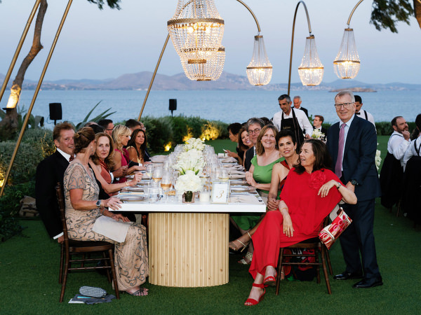 Guests seated at long reception tables overlooking the Athenian Riviera at The Residence Athens.