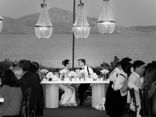 Black and white view of guests dining outdoors at Island Resort Athens Riviera wedding.