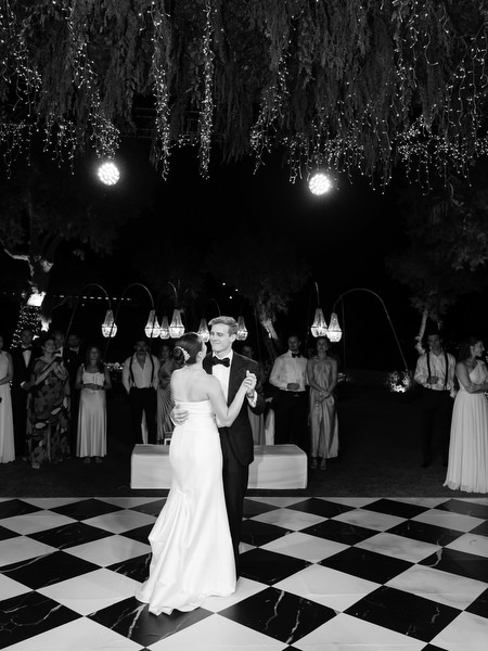 Bride and groom dancing on black and white dance floor at The Residence Island Resort Athens Riviera at night.