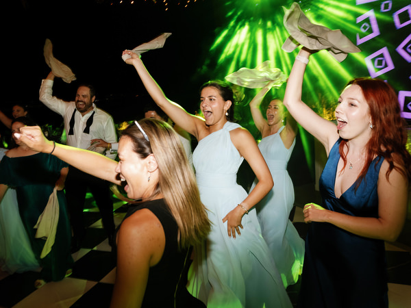 Wedding guests dancing under colorful lights at The Residence Island Resort Athens Riviera party.