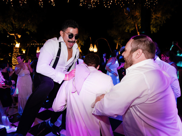 Guests lifting groomsman during late-night dance party at The Residence Island Resort Athens Riviera.