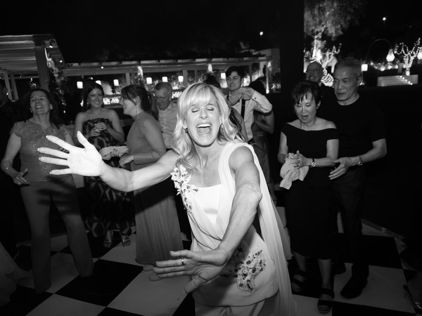Wedding guest dancing energetically on black and white dance floor at Island Resort Athens Riviera.