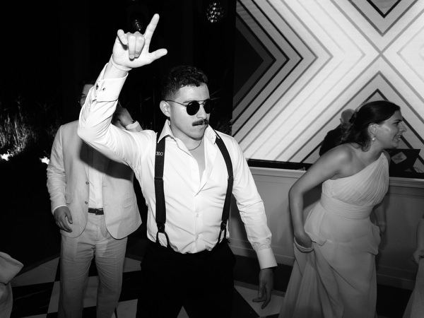 Guest dancing with sunglasses on during luxury Athens Riviera wedding reception.