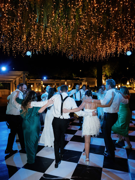 Guests dancing together under party lights at The Residence Island Resort Athens Riviera.