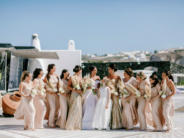 Bridal party in champagne gowns at Santorini destination wedding.