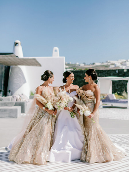 Bride with bridesmaids in gold gowns at Eros Santorini.