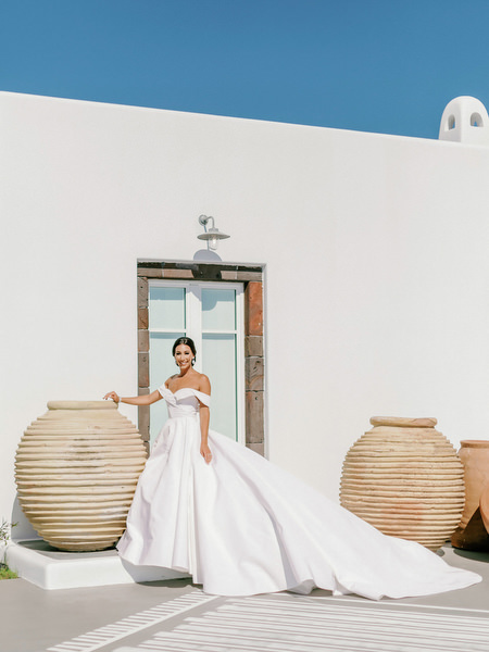 Luxury bridal portrait at Eros Santorini with white Cycladic architecture.