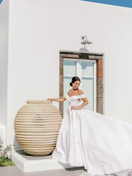 High-fashion Santorini wedding portrait with terracotta urns.