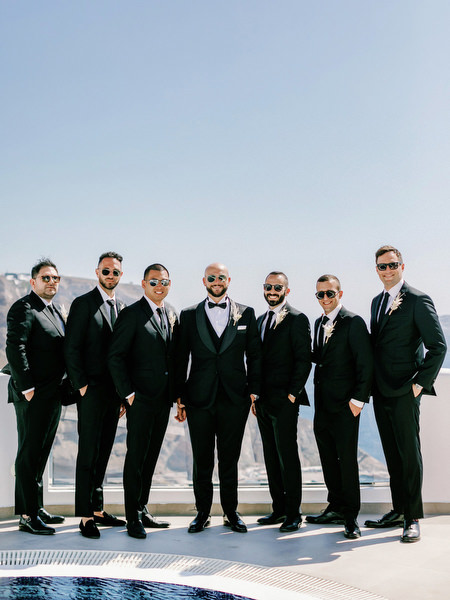 Groom and groomsmen portrait in black suits Santorini Greece.