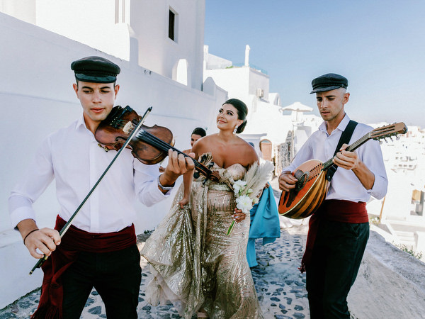 Live Greek musicians leading Santorini wedding procession.