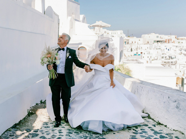 Bride and father arriving at Santorini wedding ceremony.