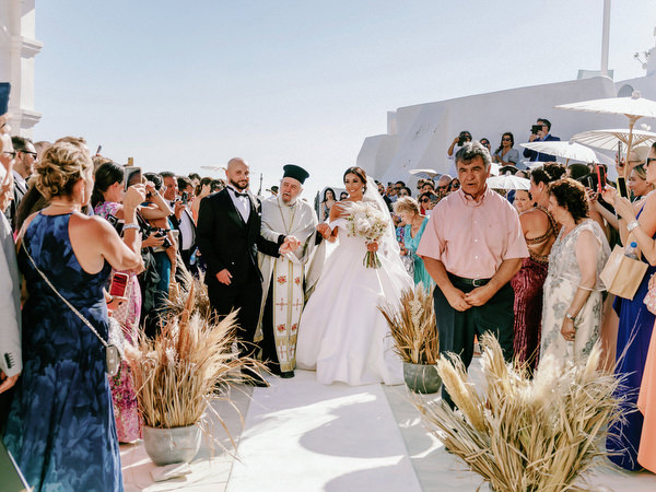 Wedding guests celebrating arrival of bride in Santorini.