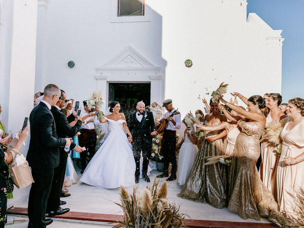Guests throwing petals outside Santorini church.