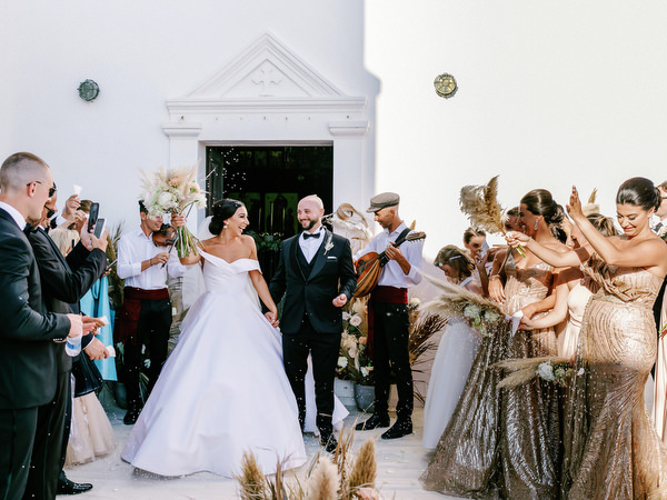 Bride and groom exiting church with celebration.