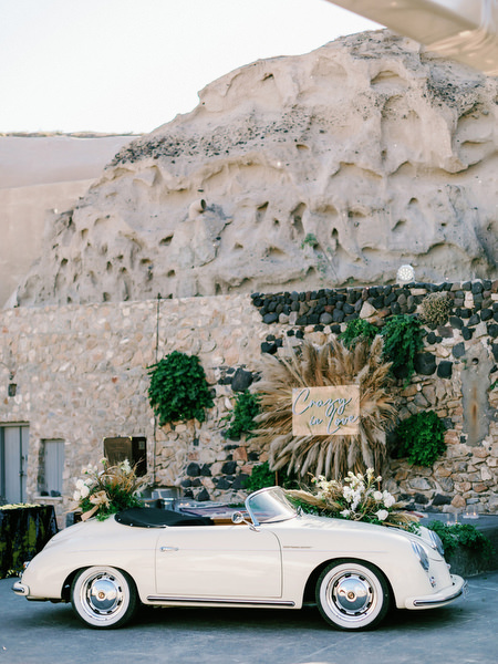 Vintage convertible outside Arts Factory Santorini wedding.
