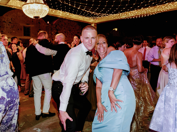 Guests dancing under chandeliers at Santorini wedding.
