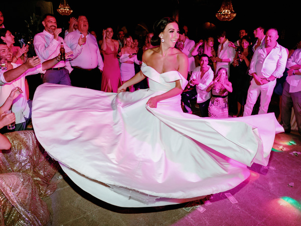 Bride dancing surrounded by guests at Santorini wedding.