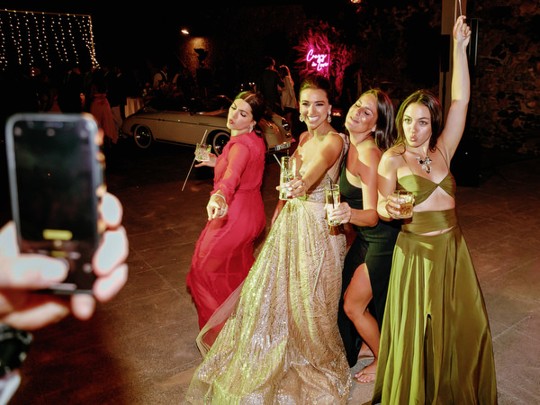 Bridesmades twirling gown on Santorini dance floor.