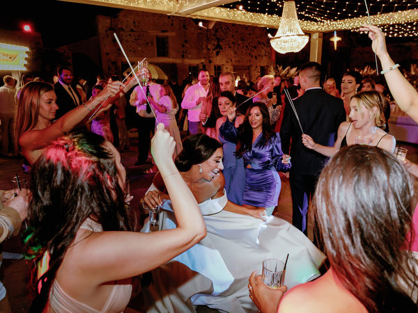 Bride dancing surrounded by guests at Santorini wedding.