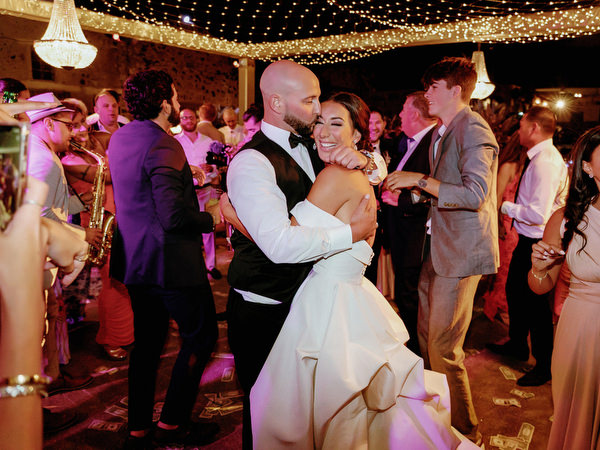 Bride and groom dancing under chandeliers Santorini.