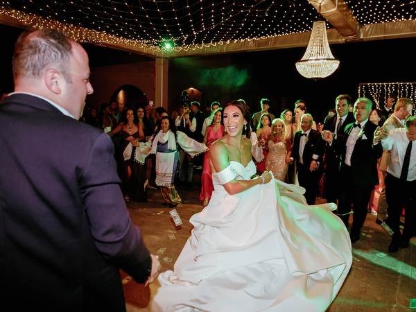 Bride twirling on Santorini wedding dance floor.