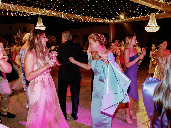 Guests celebrating under chandeliers Arts Factory Santorini.