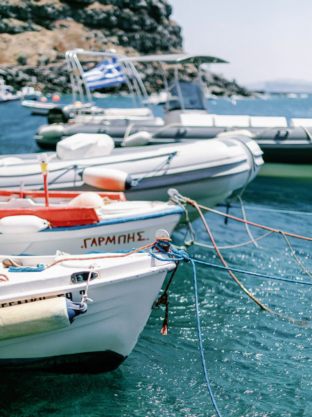 Fishing boats docked in Santorini marina for wedding boat celebration