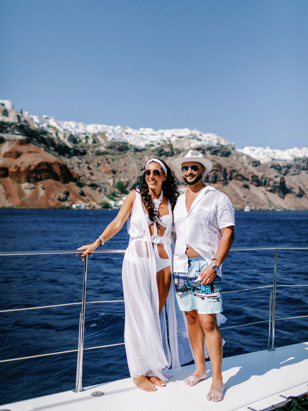 Couple posing on catamaran deck during Santorini wedding cruise