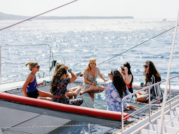 Guests relaxing on catamaran deck during Santorini wedding cruise