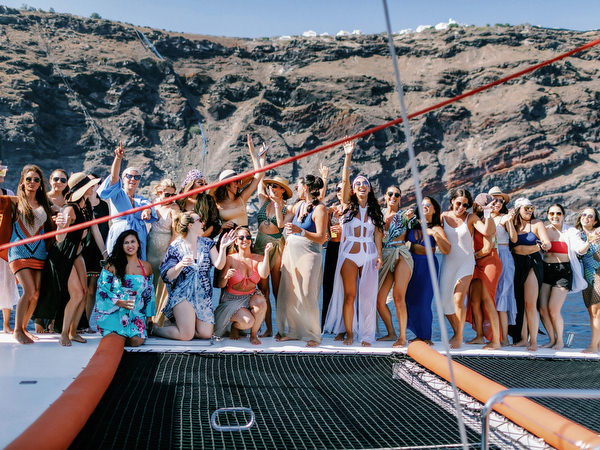 Couple and friends celebrating during Santorini sailing party