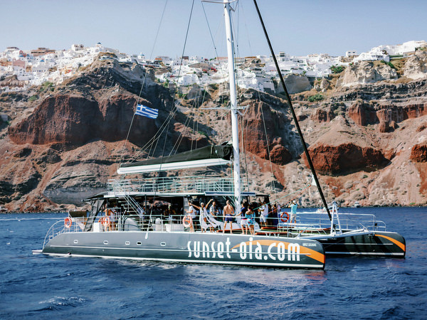 Couple posing with friends on Santorini catamaran cruise