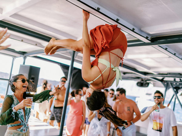 Guests dancing inside catamaran during Santorini wedding cruise
