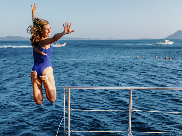Guests jumping from catamaran into the sea in Santorini