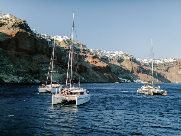 Sunset sailing moment during Santorini wedding catamaran cruise