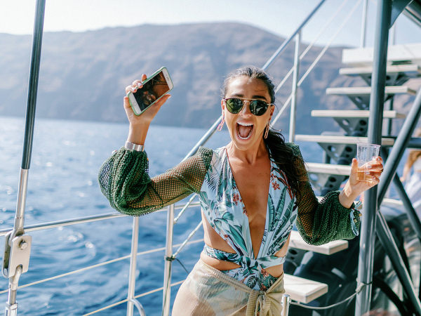 Wedding guests celebrating with drinks during Santorini boat party