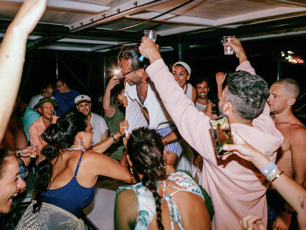 Couple celebrating with guests on Santorini catamaran