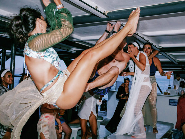 Wedding guests partying on catamaran during Santorini wedding weekend