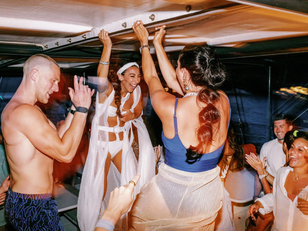 Guests celebrating final moments of Santorini wedding cruise
