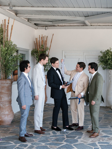 Groom preparing with friends at Athens Riviera wedding.