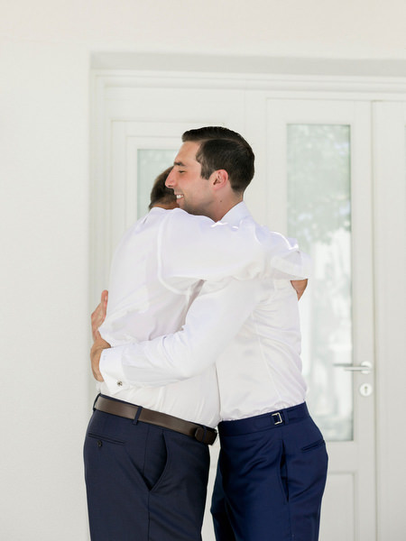 Emotional groom hug before Santorini winery wedding at Venetsanos.