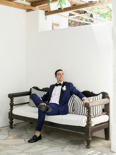 Groom relaxing in Santorini courtyard ahead of Venetsanos Winery wedding.