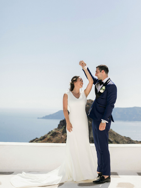 Bride and groom laughing on Santorini terrace before Venetsanos Winery wedding