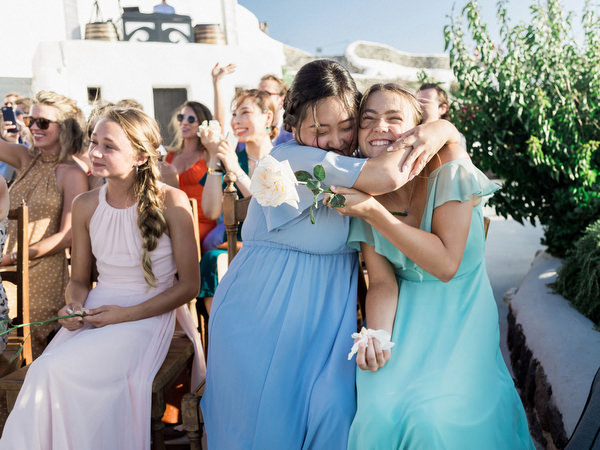Guests hugging during Santorini destination wedding at Venetsanos Winery.