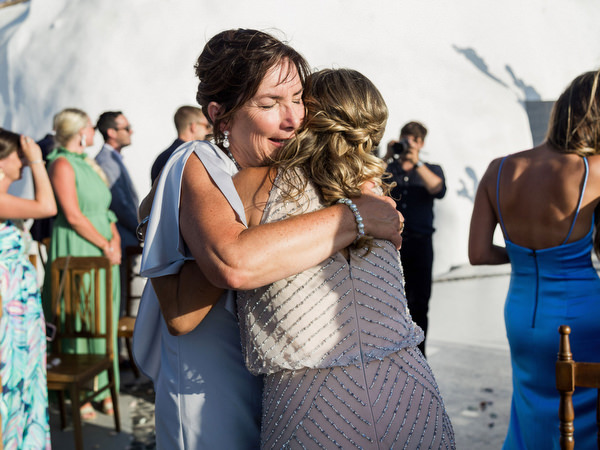 Guests hugging after Santorini wedding ceremony at Venetsanos Winery.