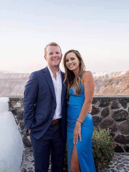 Couple portrait at Venetsanos Winery overlooking Santorini caldera at sunset.