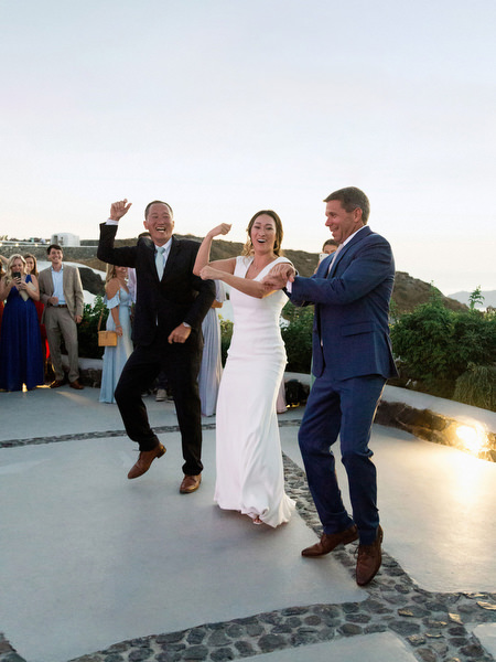 Wedding guests dancing at Santorini winery reception.