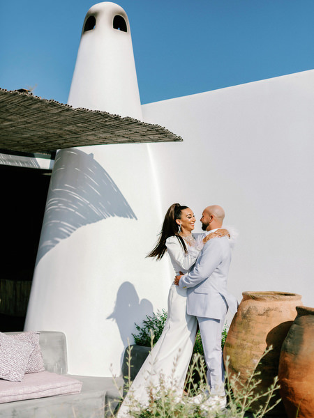 Couple portrait near Santorini stone wall with blue sky