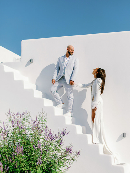 Bride and groom walking up Santorini staircase